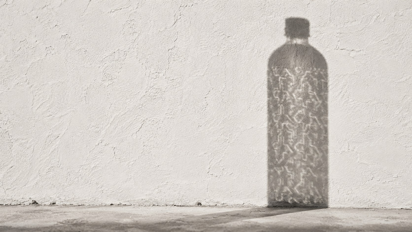 Ombre de la bouteille NATAKASSAM sur un mur